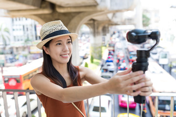 Woman using video stabilizer to take video at bangkok city