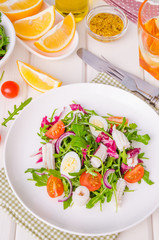 Salad with arugula, squid, cherry tomatoes, onion and quail eggs