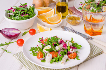 Salad with arugula, squid, cherry tomatoes, onion and quail eggs