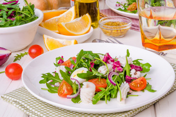 Salad with arugula, squid, cherry tomatoes, onion and quail eggs