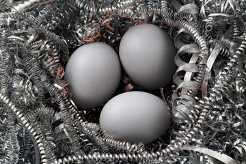 Three eggs in a nest of metal shavings