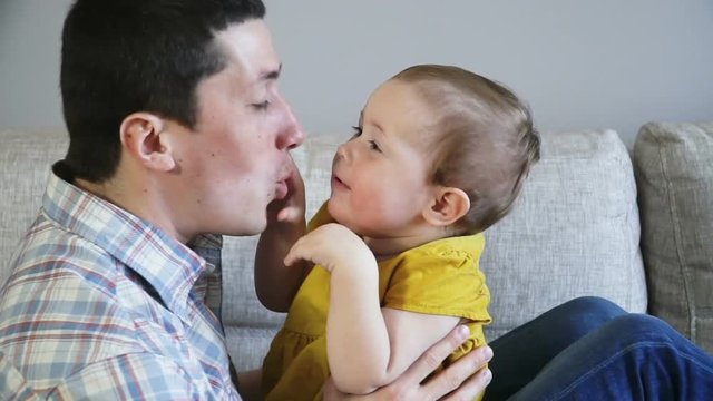 Father and his baby girl hugging, kissing and smiling, close up. Resting together. Family concept. Full Hd Slow Motion Stock Footage.
