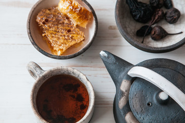Old ceramic teapot with a Cup of tea and biscuits in a bowl on wooden background