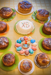 Easter cuisine. Easter cakes, curd Easter and dyed eggs stand on table. Top view.