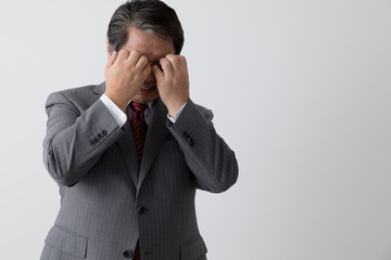 目をかくビジネスマン、痒み、中年男性