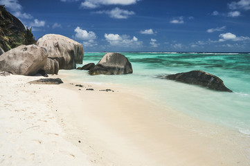 Big granite stones on the white-sand beach next to turquoise water