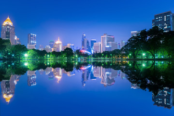 Lumpini Park at night with reflection of skyline.