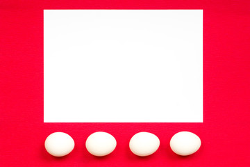 easter concept, white paper and eggs on red background