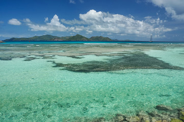 Lonely sailing ship next to amazing reef under turquoise-water