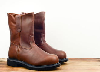 A pair of brown color leather safety boot with white background