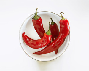 Red chili peppers in bowl on white background, top view