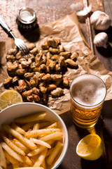 Mussels, fried potatoes, beer on the table