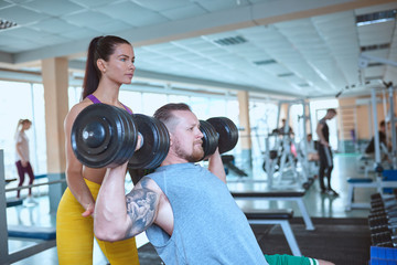 Fototapeta na wymiar Couple doing workout on fitness machine at gym.