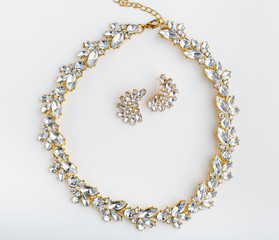 diamonds necklace a white background. Stylish necklace with colorful stones. A round gold metal necklace with crystal. Bijouterie. Women's accessories. Necklace on the neck. Valuable Jewellery.