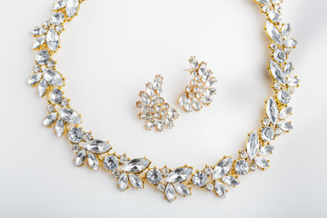 diamonds necklace a white background. Stylish necklace with colorful stones. A round gold metal necklace with crystal. Bijouterie. Women's accessories. Necklace on the neck. Valuable Jewellery.