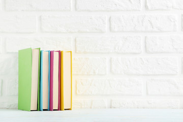 Fototapeta na wymiar Colorful books on a brick wall background
