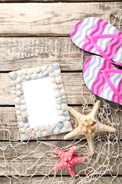 Frame of sea shells with starfish on wooden table