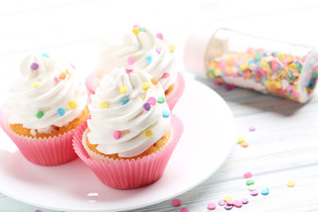 Tasty cupcakes on a white wooden table