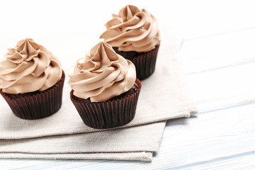 Tasty cupcakes on a white wooden table