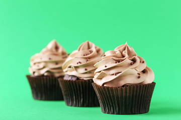 Tasty cupcake on a green background