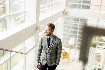 Young businessman going up the stairs in the office building