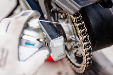 Obraz premium Lubricating motorcycle chain