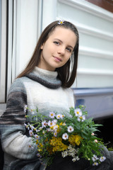 Girl teenager with flowers on the running board of a train
