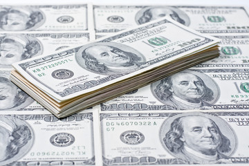 A pile of hundred dollar bills on the background of dollars  