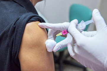  Close-up hands,nurses are vaccinations to patients using the syringe.Doctor vaccinating women in...