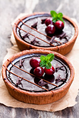 mini  chocolate tarts with cranberries on wooden background
