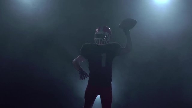 American football player makes the ball throw. Slow motion