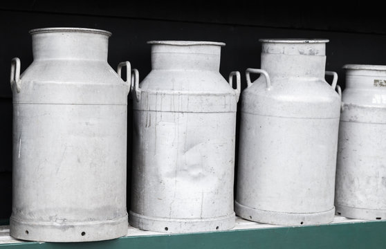 Metal milk churns stand in row