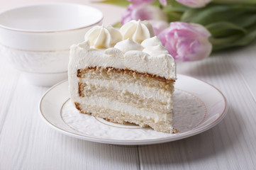 Biscuit cake with cream cheese cream on a white plate
