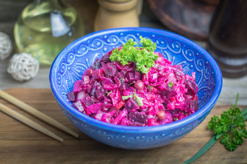 Vinaigrette vegan nutritional vegetarian salad with boiled vegetables in blue ceramic bowl on wooden rustic table. Traditional russian cuisine