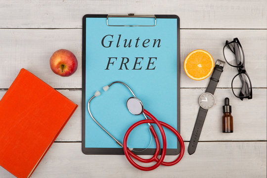 clipboard with text "Gluten free", book, eyeglasses, watch, fruit and stethoscope