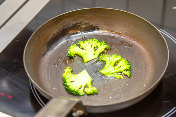 Slices of broccoli fried in a pan.