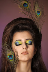 Girl with a peacock feather and creative make-up