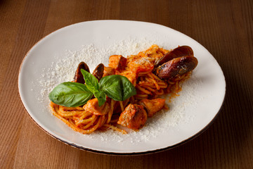Pasta with seafood on a white plate on a wooden table