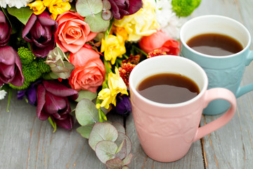 Morning Cup of coffee and a beautiful roses flowers on light background, top view. Cozy Breakfast. Flat lay style.