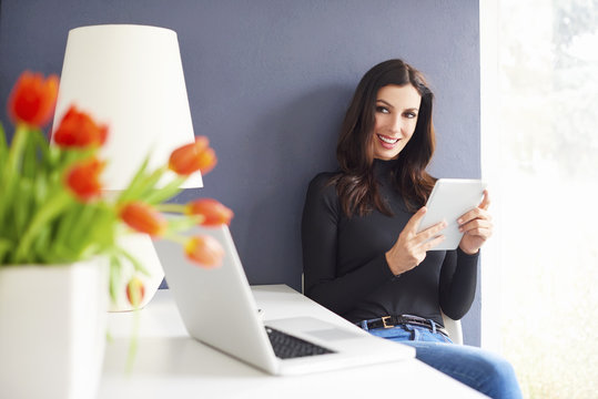 Working from home. Shot of a careworn businesswoman using her digital tablet while sitting in home office.