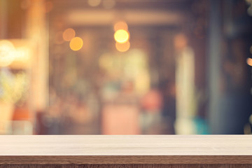Empty wooden table for product placement or montage and blurred coffee shop backdrop.