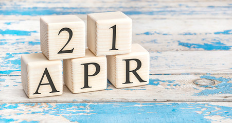 April 21st. Wooden cubes with date of 21 April  on old blue wooden background.