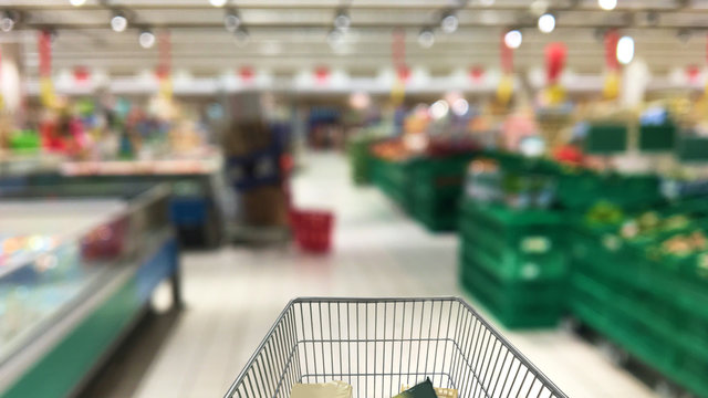 Supermercato con carrello in primo piano