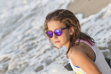 Little girl bathing on the beach with glasses.