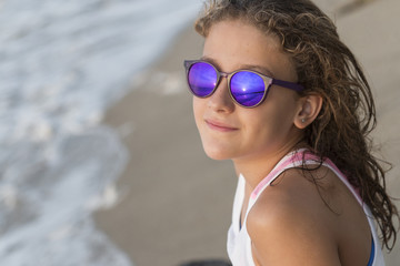 Little girl bathing on the beach with glasses.