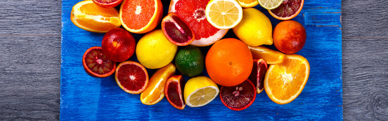 Different Citrus Fruit on a Blue Background .Mixed Colorful Tropical Background.Food or Healthy diet concept.Vegetarian.Copy space for Text. selective focus.