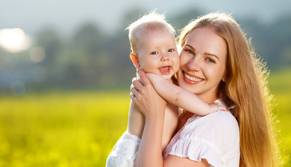 Happy family mother and baby hugging  nature in summer