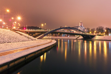 Fototapeta na wymiar Night Gediminas Tower and King Mindaugas Bridge across Neris River in the city Vilnius, Lithuania, Baltic states.