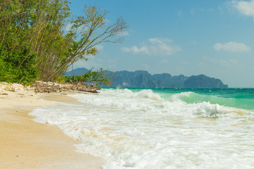 Poda island (Koh Poda) beach with trees and waves, Krabi province, Thailand