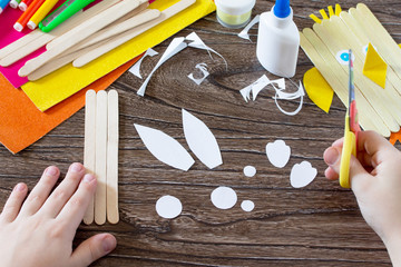 The child cuts out parts giftware. Children's Easter gift toy chicken and Easter bunny. Hand-made. The project of children's creativity, needlework, crafts for children.